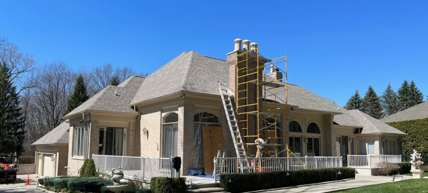 Crown crew rebuilding a chimney at a large home